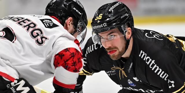 un joueur de Rouen casque noir et maillot noir fixe droit dans les yeux le joueur amiénois casque noir et maillot blanc lors de la mise au jeu 