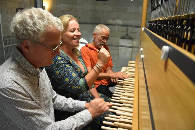 Les intervenants de "Chantons sous les cloches" réunis au clavier du carillon : l'artiste Amélie Affagard, au centre, orchestre les débats tandis que le carillonneur en chef Patrice Latour (au premier plan) ou son adjoint Vincent Bénard (au fond) accompagnent aux manettes la chorale d'un jour