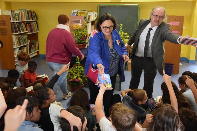 Florence Hérouin-Léautey, adjointe au maire, et Monsieur Beuzelin, directeur de l'école des Pépinières, distribuent les ouvrages aux élèves